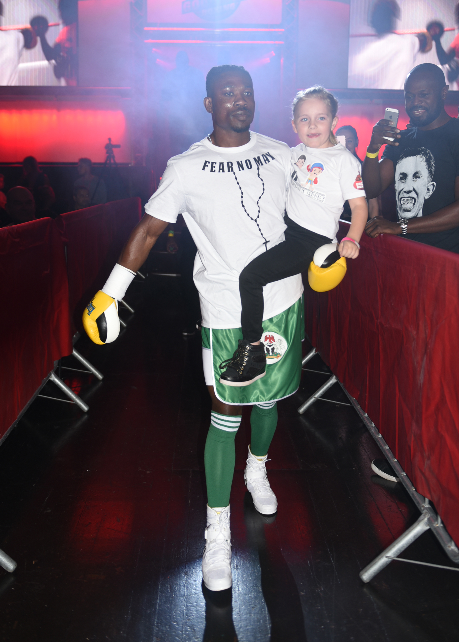 Tunji Ogunniya on the ring walk carrying a young fan